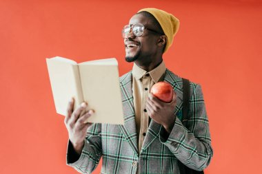 şık kitap ve izole Kırmızı elma, Afrikalı-Amerikalı adam gülüyor