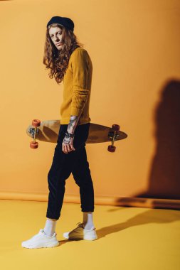 şık yakışıklı patenci longboard, sarı holding