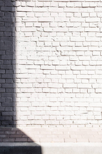 Rough textured light brick wall background with shadow