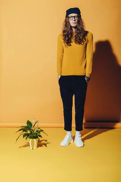 Uomo Alla Moda Con Capelli Lunghi Che Stanno Vicino Impianto — Foto stock gratuita