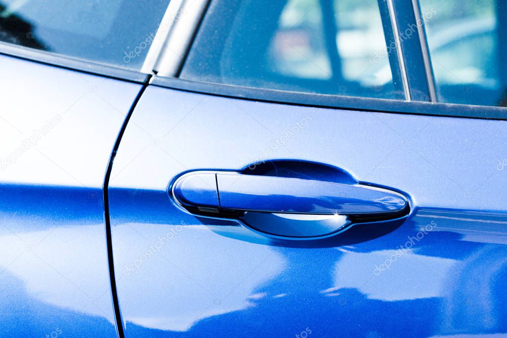 Close-up view of handle in blue car door 
