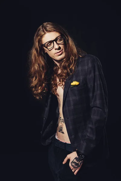 fashionable man with long hair posing for fashion shoot, isolated on black