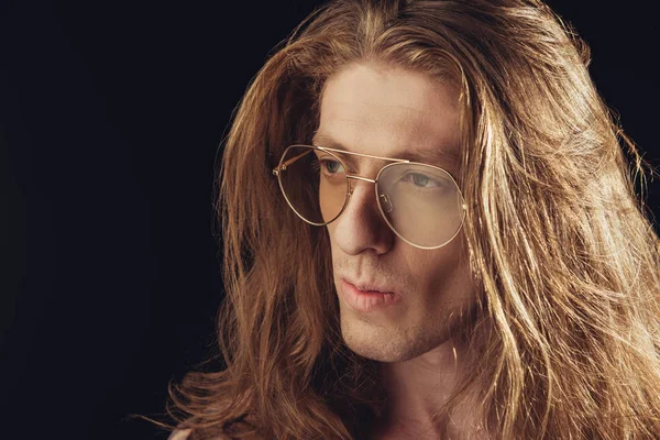 portrait of stylish man with long hair in stylish glasses, isolated on black