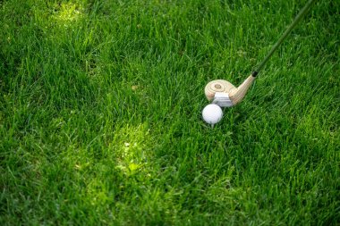 Yeşil çimenlerin üzerinde golf club ve top görünümünü kapat
