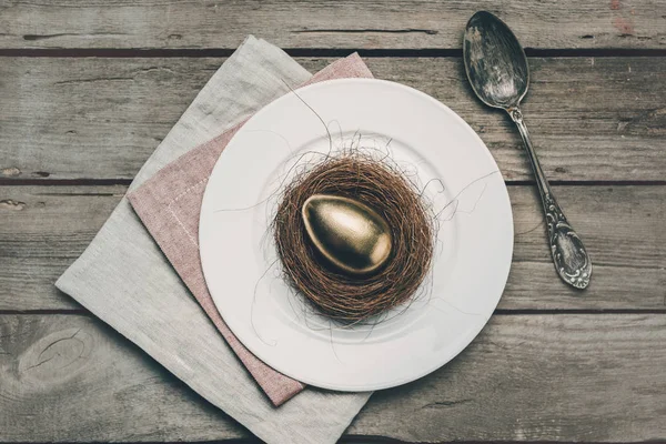 Huevo de Pascua dorado en plato - foto de stock