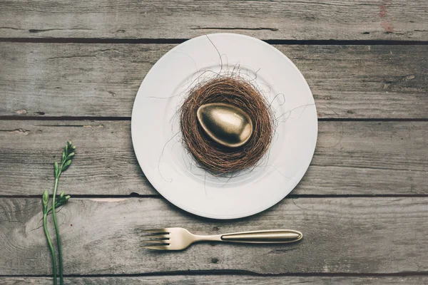 Golden Easter egg on plate — Stock Photo