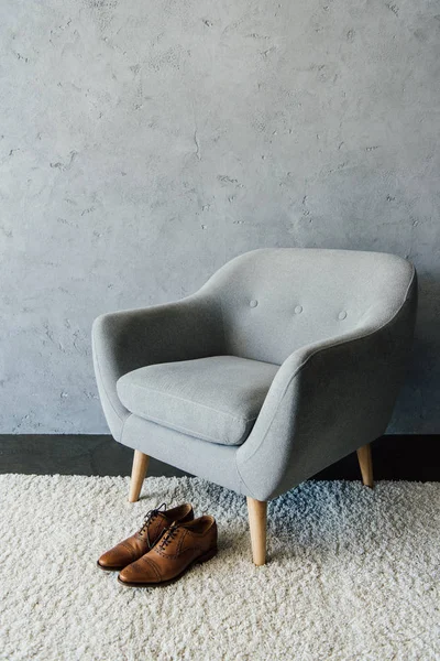 Оксфордские туфли на ковре возле кресла — стоковое фото