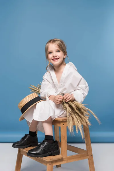 Niña con espigas de trigo - foto de stock