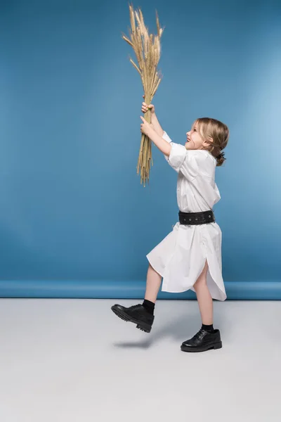 Niña con espigas de trigo - foto de stock