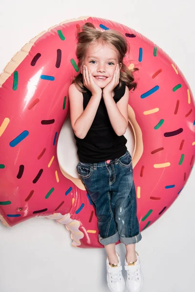 Kleines Mädchen lächelt, während es auf der Röhre liegt — Stockfoto