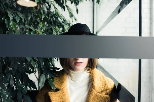 Femme en chapeau près des feuilles vertes — Photo de stock