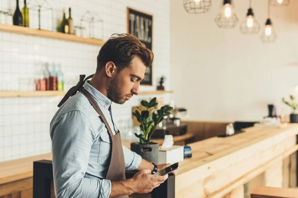 Barista using smartphone — Stock Photo