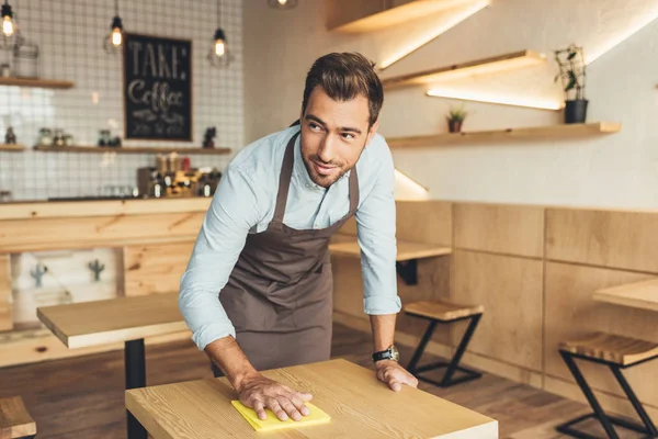 Worker cleaning table in cafe — Stock Photo