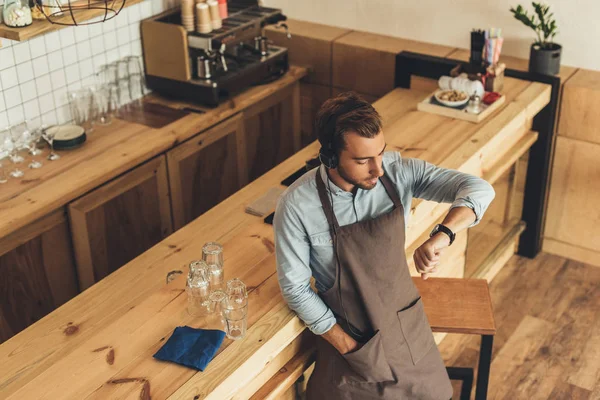 Barista dans les écouteurs au café — Photo de stock