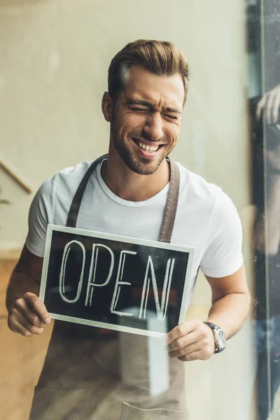 Camarero sosteniendo pizarra con palabra abierta - foto de stock