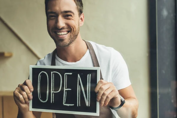 Camarero sosteniendo pizarra con palabra abierta - foto de stock