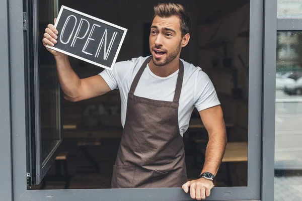 Camarero sosteniendo pizarra con palabra abierta - foto de stock
