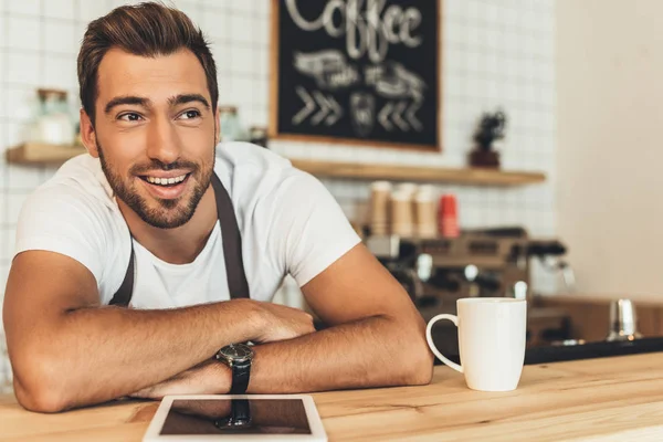 Smiling barista at counter with tablet — Stock Photo