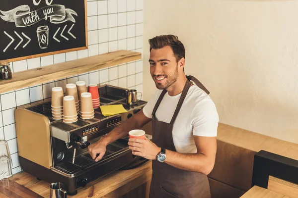 Smiling barista with coffee to go — Stock Photo