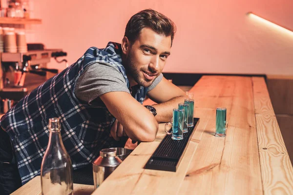 Barman with alcohol shots on counter — Stock Photo