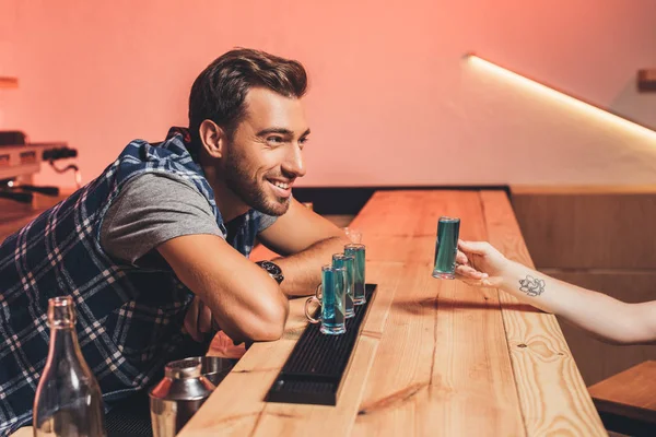 Barman with alcohol shots on counter — Stock Photo