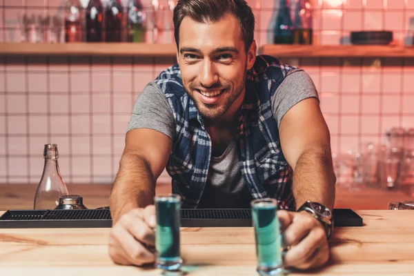 Barman with alcohol shots on counter — Stock Photo