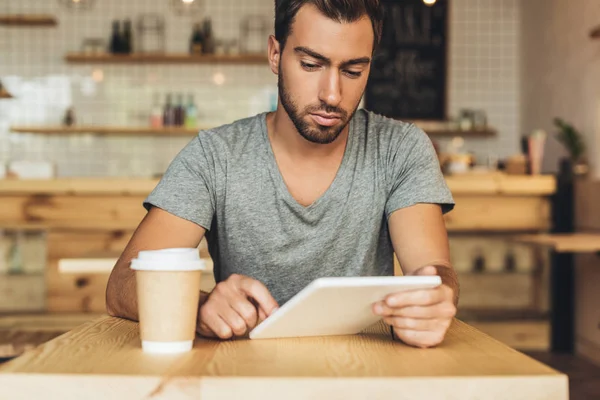 Homme utilisant une tablette dans un café — Photo de stock