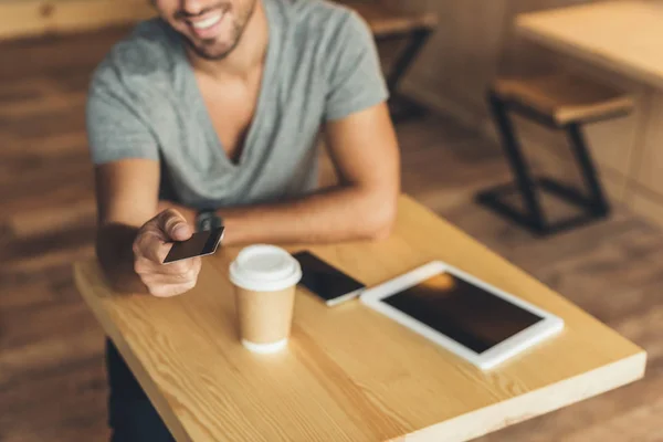 Hombre con tarjeta de crédito en la cafetería - foto de stock