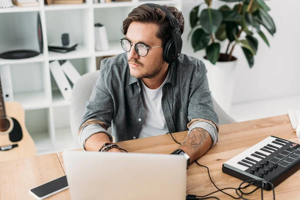 Jovem músico trabalhando com laptop — Fotografia de Stock