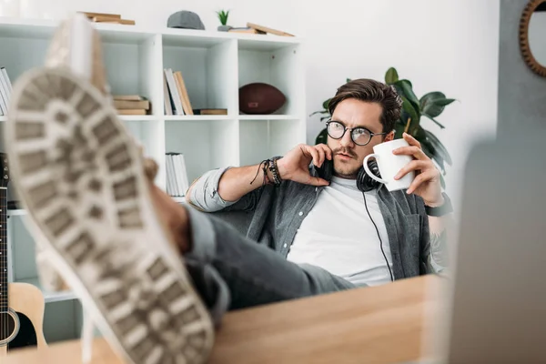 Hombre con auriculares beber café - foto de stock