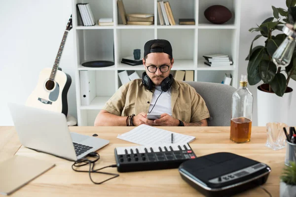 Musiker nutzt Smartphone am Arbeitsplatz — Stockfoto