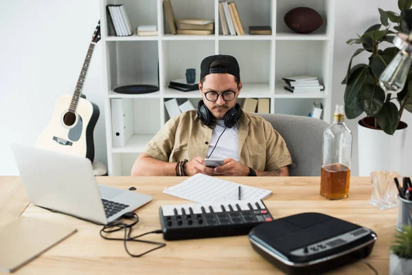 Musicista utilizzando smartphone sul posto di lavoro — Foto stock