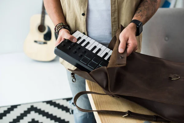 Музыкант кладет подушечку MPC в сумку — стоковое фото