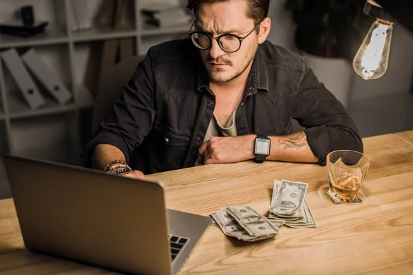 Man with whiskey and pile of cash — Stock Photo
