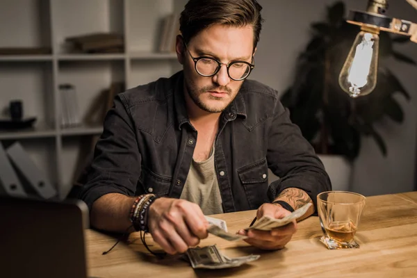 Schöner Mann beim Zählen von Bargeld — Stockfoto