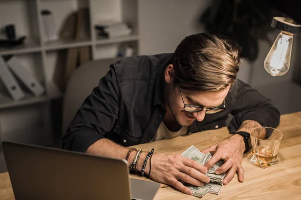 Drunk man with heap of cash — Stock Photo