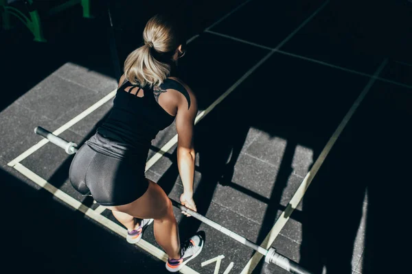Спортсменка поднимает штангу в тренажерном зале — стоковое фото