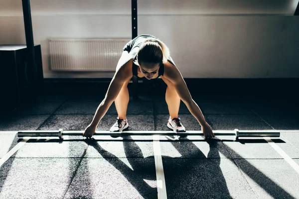 Sportswoman lifting barbell — Stock Photo