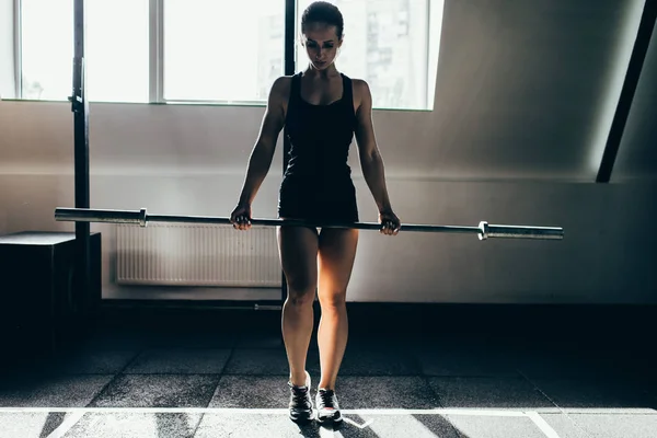 Sportswoman lifting barbell — Stock Photo