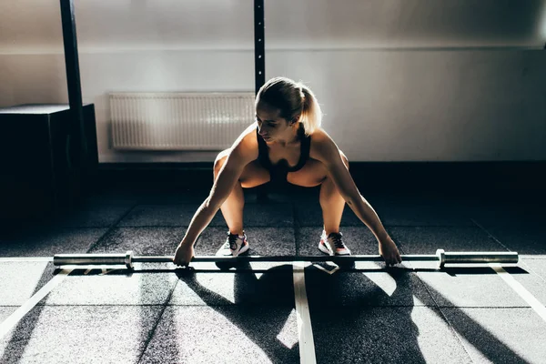 Sportswoman lifting barbell — Stock Photo