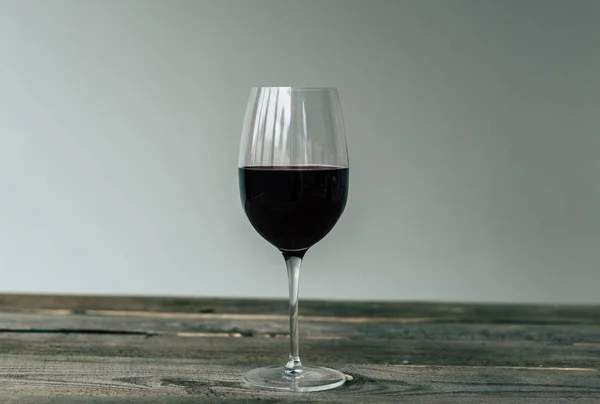 Copa de vino tinto en la mesa - foto de stock
