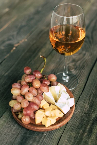 Copo de vinho e prato com uvas e queijo — Fotografia de Stock