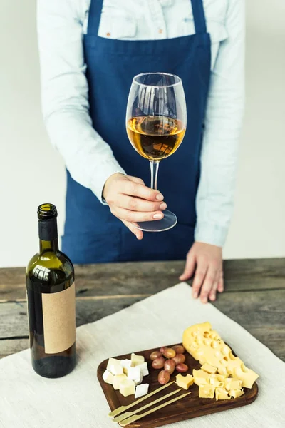 Sommelier holding glass of white wine — Stock Photo