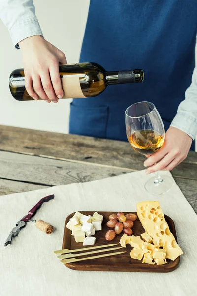 Mulher derramando vinho branco em vidro — Fotografia de Stock