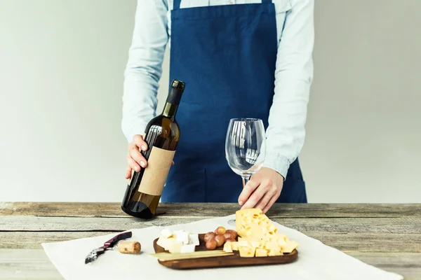 Sommelier segurando garrafa de vinho e vidro — Fotografia de Stock