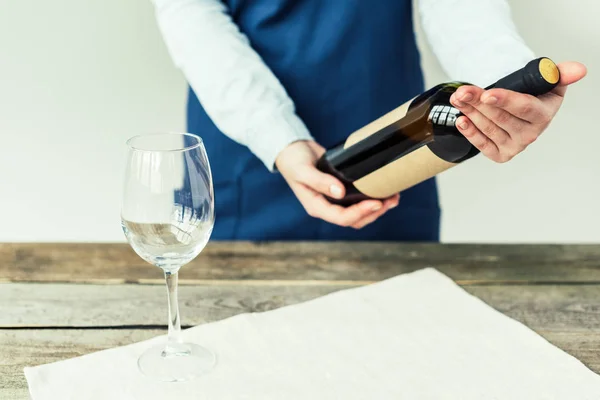 Sommelier regardant une bouteille de vin blanc — Photo de stock