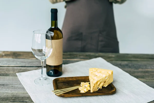 Bouteille de vin avec verre vide et fromage — Photo de stock