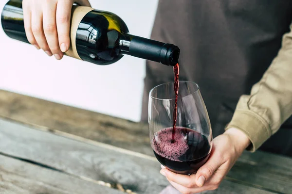 Sommelier verter vino tinto en el vaso — Stock Photo