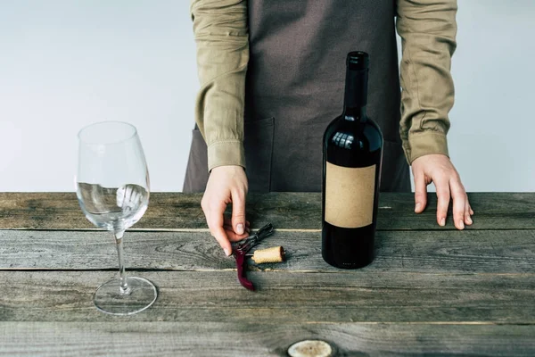 Sommelier de pie con botella abierta de vino — Stock Photo