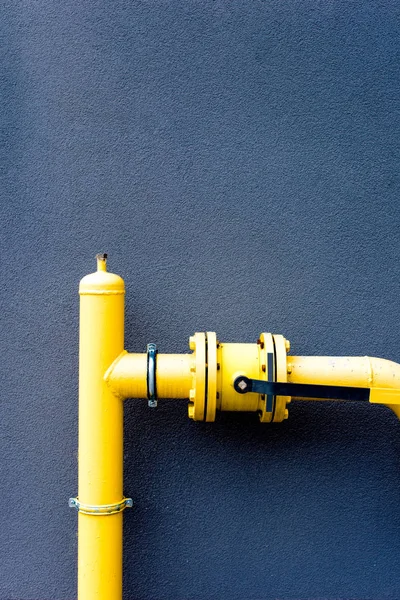 Tubo de gas amarillo y pared azul - foto de stock